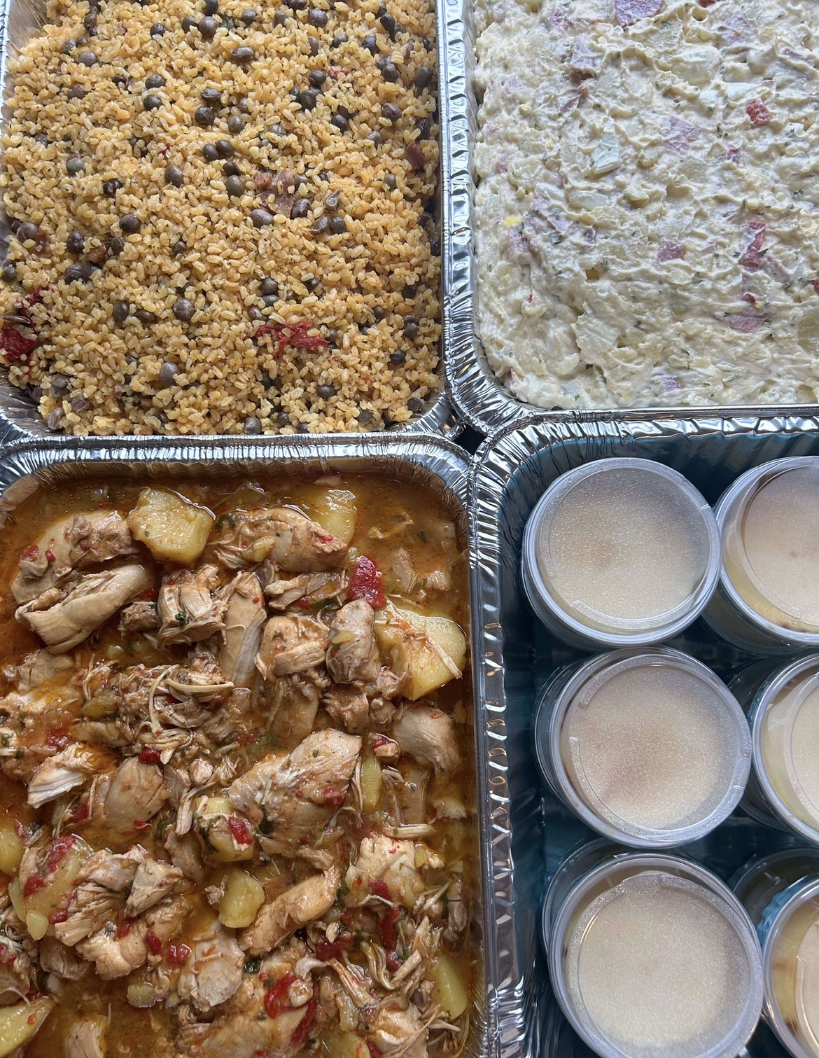 Puerto Rican catering trays with rice, salad, chicken and dessert